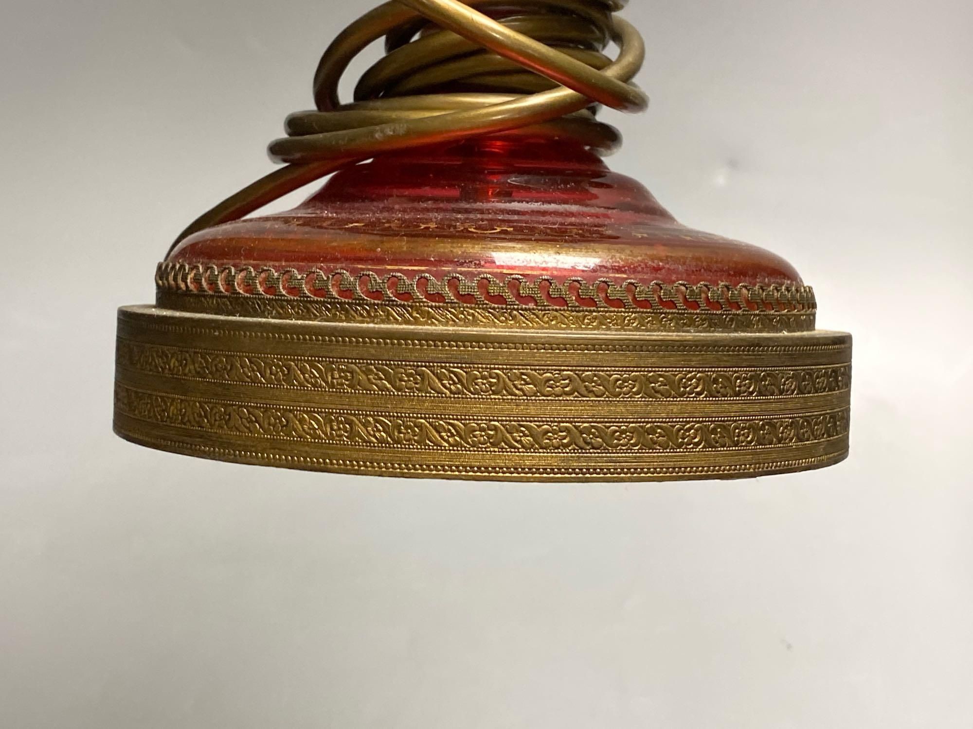 A 19th century Bohemian overlay ruby glass lamp, on engraved brass plinth, 34cm excluding light fittings